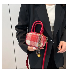 Detail of red and white checkered tweed mini bag with leather handles and gold charms