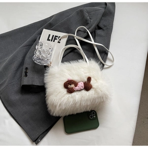 Détail du sac à bandoulière en fausse fourrure blanche avec écusson chien mignon à plat