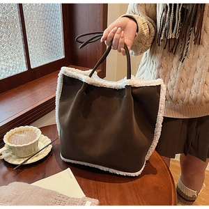 Détail du sac fourre-tout vintage en laine d'agneau et daim sur une table en bois