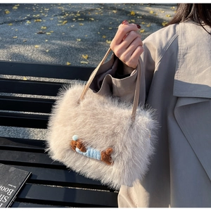 Détail du sac à main beige en fausse fourrure avec un charm de chiot en extérieur