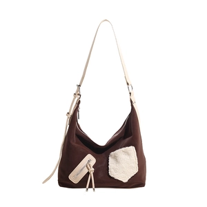 Detail of hobo shoulder bag with brown faux suede and white sherpa fleece patchwork