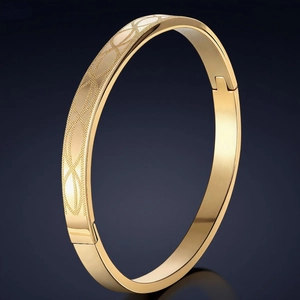 Elegante bracciale in acciaio al titanio dorato con motivo ovale inciso e chiusura