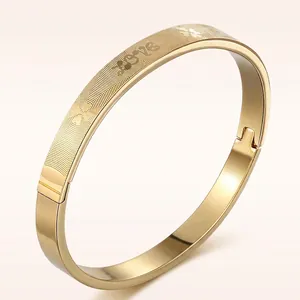 Golden titanium steel bangle with LOVE engraving and heartbeat texture shown from a side view