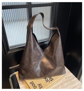 Close-up of a dark brown matte leather hobo bag with unique triangular geometric design