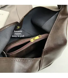 Detail view of smooth golden zipper and inner pocket on dark brown leather bag
