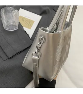 Close-up of silver bucket bag with quilted rhombic texture and metallic hardware