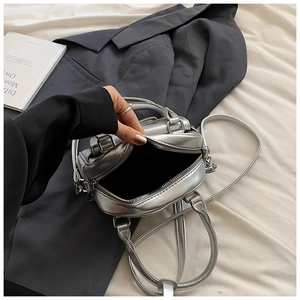 Detail view of the black fabric lining inside the silver metallic bow shell bag