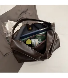 Interior detail of a dark brown tote bag showing spacious compartments for gadgets