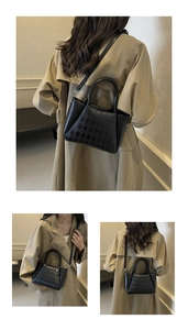 Detail of black quilted bucket bag with top handle and adjustable shoulder strap