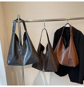 Detailed view of large leather tote bags with diagonal stitching in black and brown shades