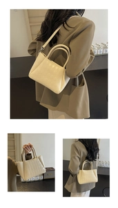 Detail view of a beige quilted bucket bag with woven texture and detachable strap