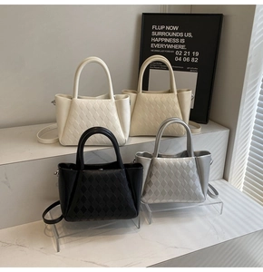 Detail of four quilted mini tote bags in white, cream, black, and silver finishes
