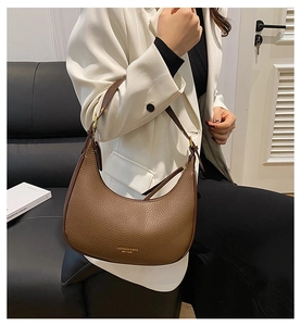 Close-up of brown litchi pattern leather hobo bag with gold metal logo and zipper detail