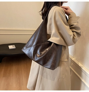 Detail of soft leather shoulder bag showing the unique geometric triangle folding design