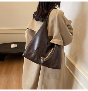 Detail view of large brown vintage tote bag with modern triangular soft leather tailoring