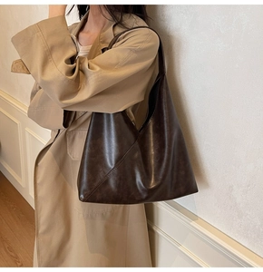 Detail of dark brown hobo shoulder bag with diagonal stitching on soft retro leather