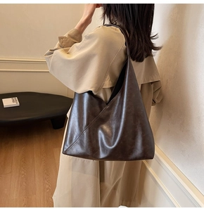 Detail of dark brown vintage tote bag showing geometric stitching and soft leather texture