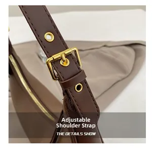 Macro view of adjustable shoulder strap with gold-tone hardware on dark brown leather bag