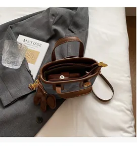 Overhead shot of brown tote bag interior featuring zipper pocket and elephant charm detail