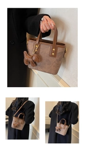 Detail of vintage brown monogram bucket bag with cute bear charm and gold hardware