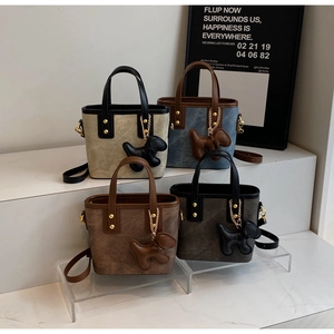 Detail of suede mini bucket bags in four colors with cute puppy charms and gold rivets