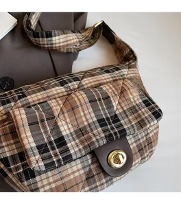 Détail d'un sac à carreaux matelassé avec texture douce et fermoir rotatif doré chic