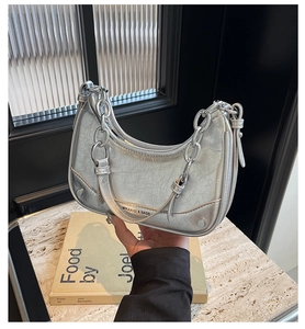 Detail of silver metallic hobo bag with thick chain strap and textured leather finish