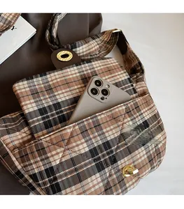 Gros plan d'un sac à carreaux marron avec une poche avant pratique pour un téléphone