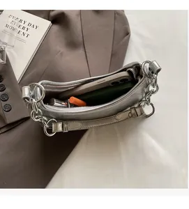 Silver metallic baguette bag showing interior capacity for phone and lipstick