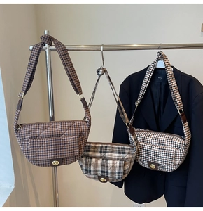 Détail de sacs à bandoulière matelassés à carreaux avec fermoirs rotatifs en métal doré