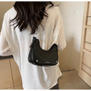 Glossy black crescent underarm bag with thick silver chain on white T-shirt model