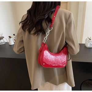 Detail of red crescent hobo bag with glossy oil wax leather and silver metal chain