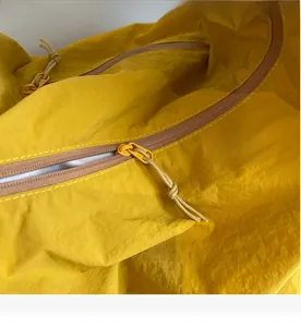 Detail of smooth yellow zipper on a nylon tote bag with high-quality stitching