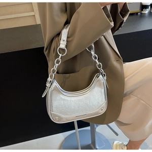Detail of silver metallic underarm bag showing vintage crinkled texture and metal chain