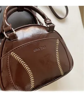 Close-up of glossy wrinkled leather texture and contrast stitching on a brown handbag