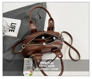 Vue intérieure détaillée du sac en cuir marron avec poches zippées et doublure rayée