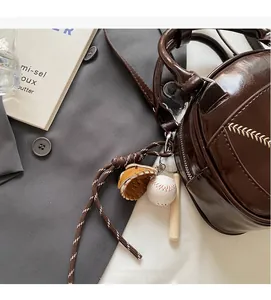 Detailed shot of dark brown oil wax leather handbag with baseball theme charm accessory