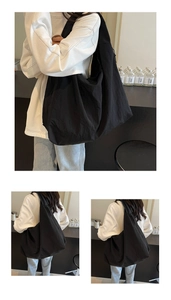 Detail view of a large black nylon tote bag with wide straps and zip closure design
