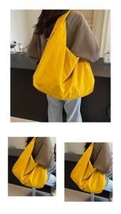 Detail view of large yellow canvas shoulder bag in a modern minimalist lifestyle setting