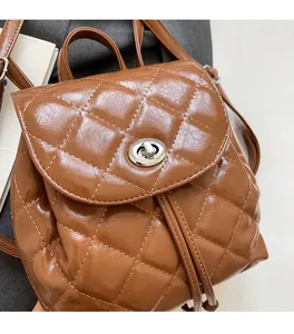Détail d'un sac à dos en cuir matelassé marron avec fermoir rotatif argenté