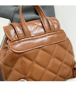Gros plan d'un sac à dos marron matelassé montrant les coutures et les détails de l'anse