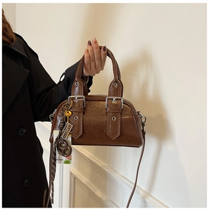 Détail du sac Boston marron rétro en cuir ciré avec pendentif boulier et boucles