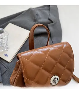 Détail d'un sac à dos en cuir matelassé marron avec fermoir tournant en métal et poignée