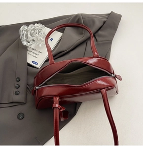 Top view of opened burgundy glossy Boston bag showing interior lining and zipper detail