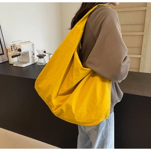 Detail view of large yellow puffy hobo bag made of lightweight parachute nylon fabric