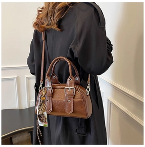 Détail du sac bandoulière marron foncé avec plis vintage et accents métalliques argentés