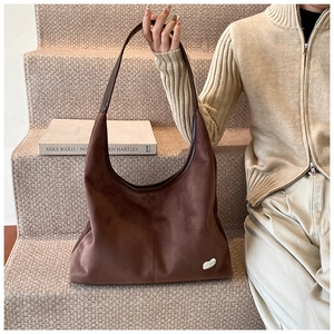 Close-up of large coffee brown suede tote bag featuring unique logo on soft fabric