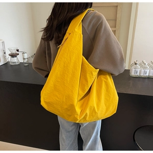 Detailed back view of a bright yellow nylon puffer shoulder bag for women