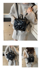 Détail d'un mini sac à dos noir matelassé avec fermoir rotatif argenté et élégant
