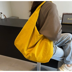 Detailed view of lightweight yellow parachute fabric tote bag showing soft pleat texture
